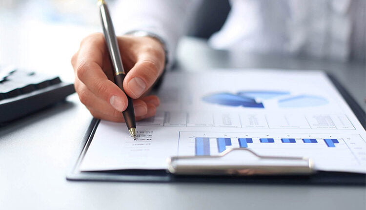 ما هي دراسة الجدوى؛ أهميتها وأنواعها لتحقيق الاستثمار الناجح لمشروعك 2 دراسة الجدوى وانواعها يد رجل يكتب في ورقة دراسة جدوى