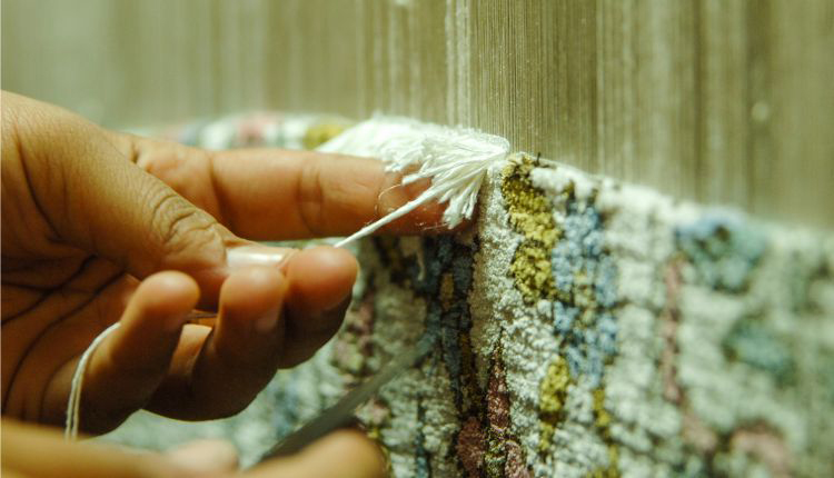 الادوات الخاصة بصناعة السجاجيد اليدوية صورة ليد تقوم بنسج السجاد