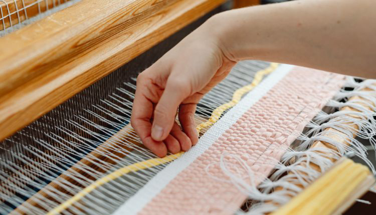 أفضل طرق لعمل السجاد اليدوي على النول صورة يظهر بها يد تقوم بعمل السجاد على النول